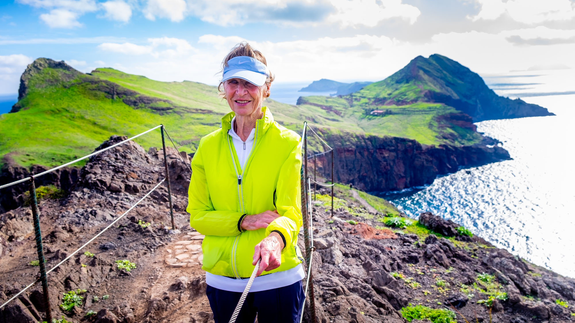 Ane on the dramatic Madeira peninsula with green cliffs behind her